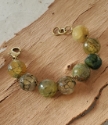 Green and teal round gemstone bracelet on wood