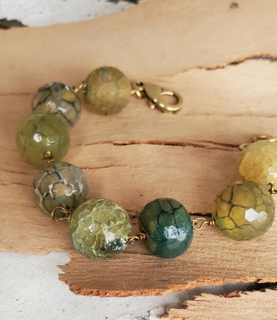 close up of Green and teal round gemstone bracelet on wood