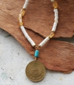 White, turquoise, yellow gemstone Argentina coin necklace on wood