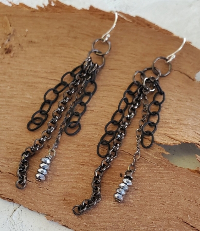 black mixed chain silver hematite earrings on wood