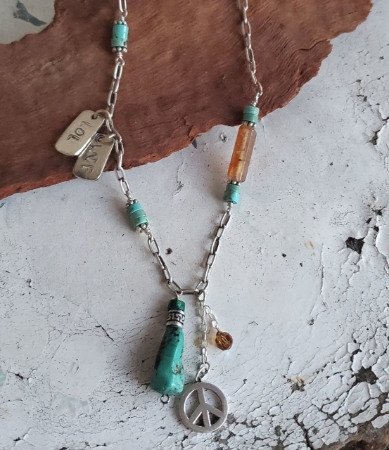 Peace charm turquoise silver chain necklace on table