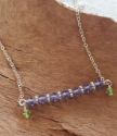 Up close Purple and green Swarovski crystal bar necklace on wood