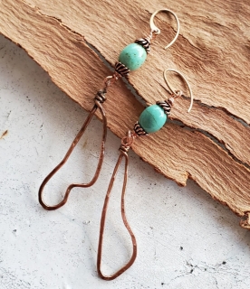 long turquoise copper earrings on wood