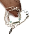 Silver double wrap birthstone charm bracelet on white with wood