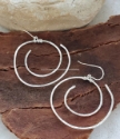 silver spiral earrings on wood