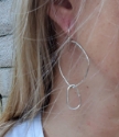Organic silver oval hoop earrings on model