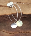 Silver hoop drop disc earrings on wood