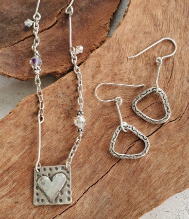 abstract silver earrings & eclectic heart necklace on wood