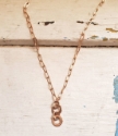 Double bronze ring paperclip chain necklace white distressed wood