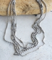 layered silver chain necklace on rock