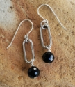 bold black gemstone silver oval earrings on rock