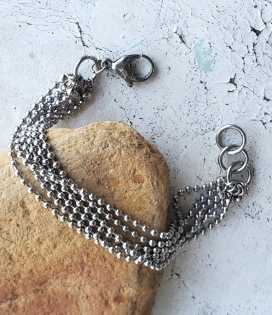 Silver bead ball chain multi layered bracelet on rock