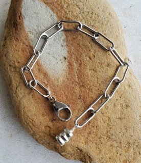 Silver paper clip chain bracelet displayed on rock