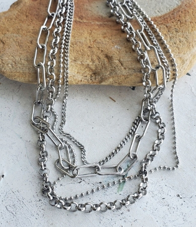 Thick silver mixed chain layered necklace on rock