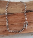 Silver toggle chain necklace on wood display