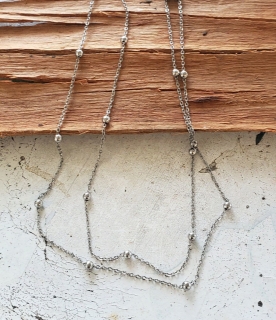 thin silver ball chain layered necklace on wood