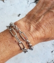 wearing 2 wide silver chain bracelets