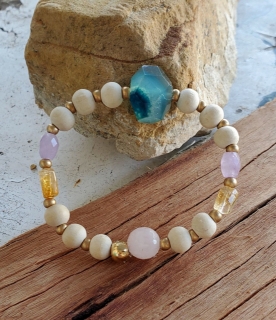 Pastel gemstone bracelet on wood and rock