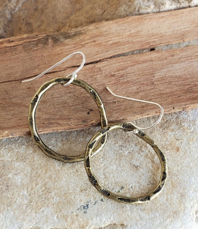 textured brass hoop earrings on rocks