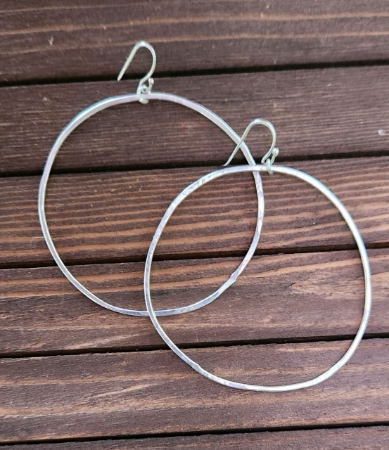 hammered 2" silver hoop earrings on wood