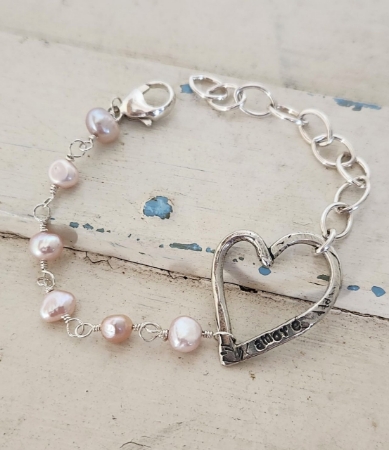 Silver open heart light pink pearl chain link bracelet on white wood