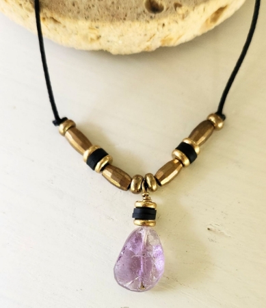 Blended purple yellow gemstone raw brass necklace on rock