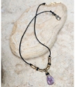purple gemstone raw brass black cord necklace on stone