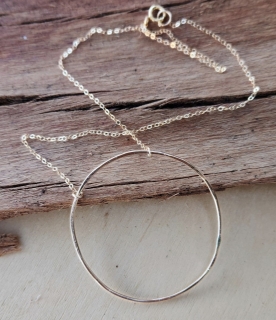 Hand-crafted Gold open circle chain necklace on wood