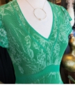 gold circle necklace with white pearl on mannequin in green dress