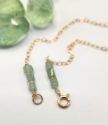 Green fluorite gold framed necklace clasp on white with gemstones surrounding it