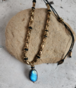 labradorite brass bead necklace on a rock