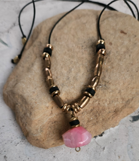 light pink agate brass bead, black cord necklace on rock