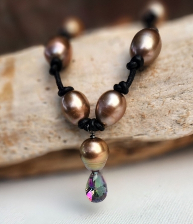 brown pearl necklace knotted on black leather with a rainbow topaz pendant up close