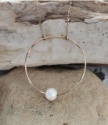 big gold hammered circle, white floating pearl necklace on rocks