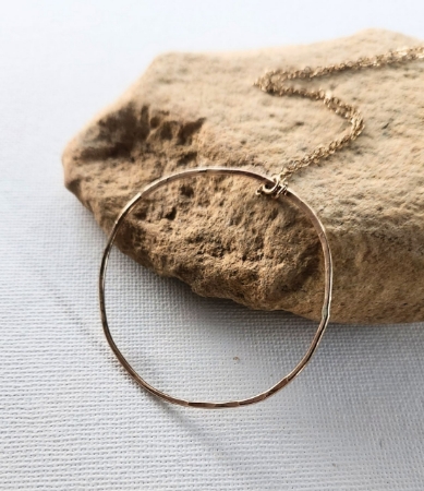 Modern gold hammered open circle chain necklace on rock