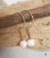 gold mini hoop white pearl stick earrings on wood