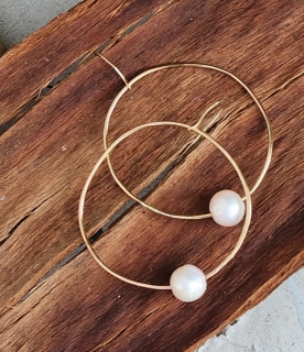 white floating pearl gold hoop earring on wood