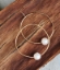 white floating pearl gold hoop earring on wood