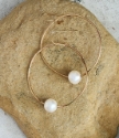 white floating pearl gold hoop earring on rock