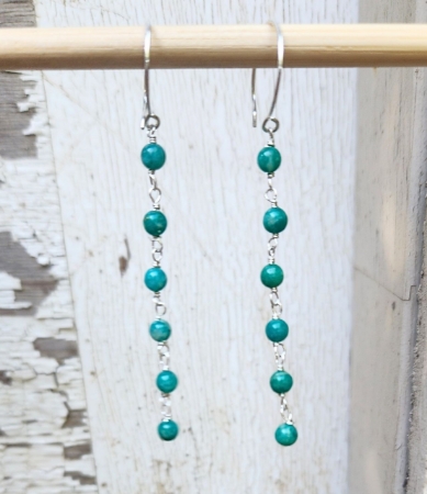 Green amazonite long cascading earrings on white wood