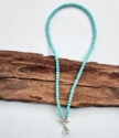 aqua blue beads surround rainbow quartz pendant necklace full view on wood