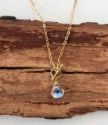 close up rainbow quartz gold chain toggle necklace on wood