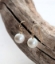 big white singular pearls earrings with gold ear wire on wood branch
