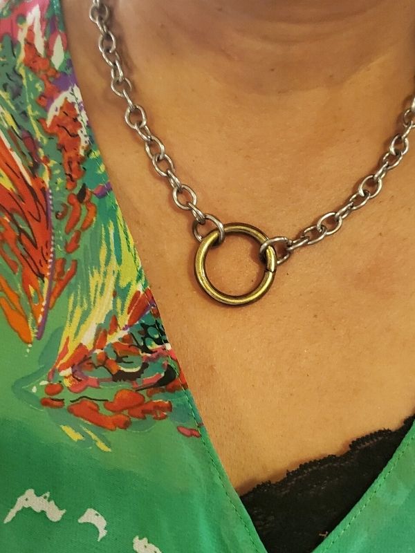 chunky silver chain gold ring necklace on neck with green top