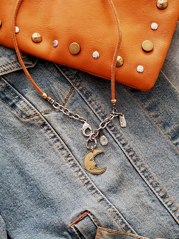 brass moon leather necklace on denim