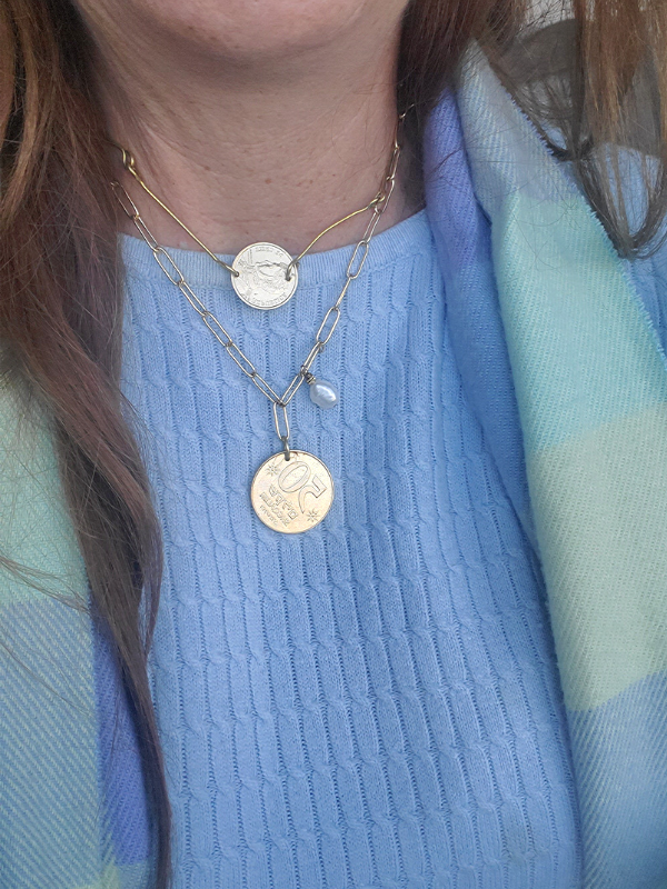 female wearing scarf and layered coin necklaces