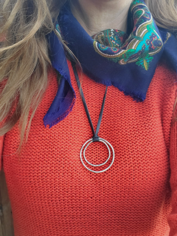 long silver circle black leather necklace with red sweater