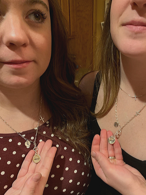 2 moms holding mom necklaces