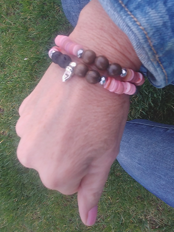 pink essential oil bracelet worn with denim