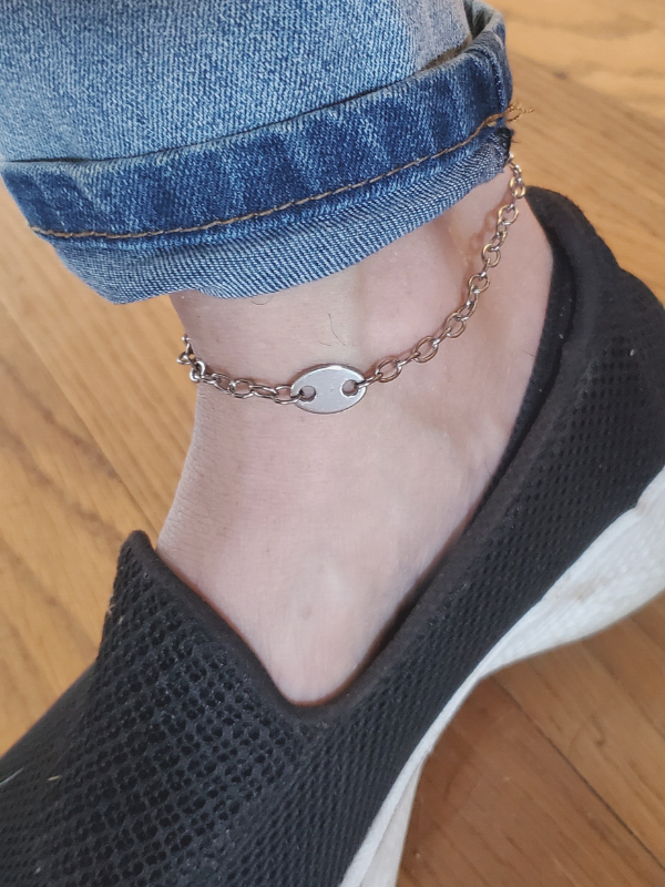 silver anklet on foot with black sneaker